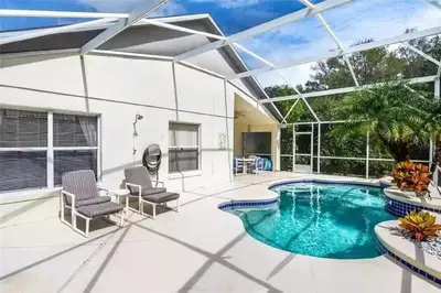 a swimming pool in a house with two chairs at Disney area 4-bedrooms spacious villa for rent in Kissimmee