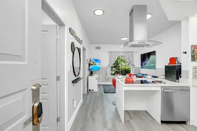 a white kitchen with a desk and a window at Disney Accessibility Star Wars Vacation Apartment Near Parks in Orlando