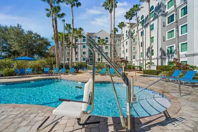 a swimming pool with a slide in front of a building at Disney Accessibility Star Wars Vacation Apartment Near Parks in Orlando