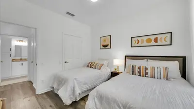 two beds in a bedroom with white walls at BF 2Bedrooms 2303 - 102 in Kissimmee