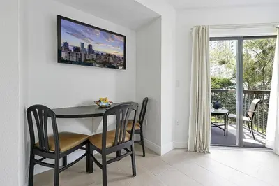 a dining room with a table and chairs and a balcony at 6165 CARRIER DR #1212 ORLANDO 1BED in Orlando