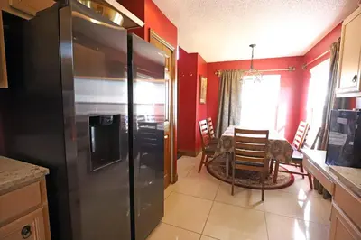 a kitchen with a refrigerator and a dining room at Enchanted Villa with Lake View 6-Bedroom in Resort 9 miles to Disney World 15 miles to the Wizarding World of Harry Potter in Kissimmee