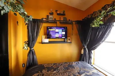 a bedroom with a bed with black curtains and a tv at Waterfront 6-Bedroom Wizarding Villa in Lake Berkley Near Universal Studio's Harry Potter in Kissimmee