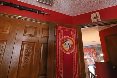 a red wall with a door with a crest on it at Waterfront 6-Bedroom Wizarding Villa in Lake Berkley Near Universal Studio's Harry Potter in Kissimmee