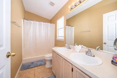 a bathroom with two sinks and a toilet at Family-Friendly 5-Bedroom Home With Pool Near Disney in Orlando