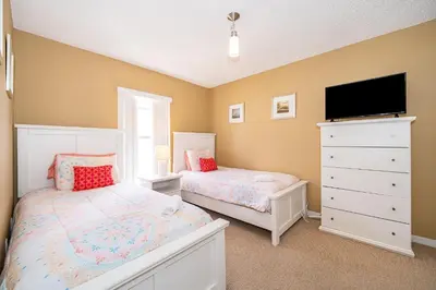a bedroom with two beds and a flat screen tv at Family-Friendly 5-Bedroom Home With Pool Near Disney in Orlando