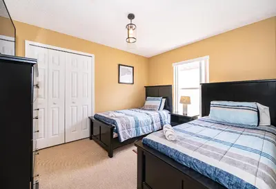a bedroom with two beds and yellow walls at Family-Friendly 5-Bedroom Home With Pool Near Disney in Orlando