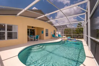 a swimming pool in a house with a large glass ceiling at Family-Friendly 5-Bedroom Home With Pool Near Disney in Orlando