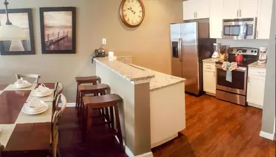 a kitchen with a counter and a table and a refrigerator at Villa Rios Camilo - Lucaya Village in Kissimmee