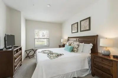 a bedroom with a white bed and a television at Villa Port - Lucaya Village in Kissimmee