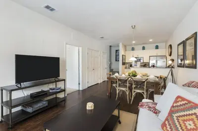 a living room with a couch and a table with a tv at Villa Port - Lucaya Village in Kissimmee