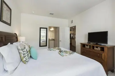 a bedroom with a bed with a flat screen tv at Villa Port - Lucaya Village in Kissimmee