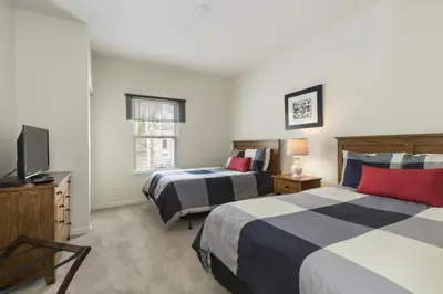 a bedroom with two beds and a flat screen tv at Villa Port - Lucaya Village in Kissimmee