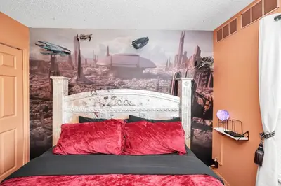 a bedroom with a bed with a mural of a city at Galactic 7-Bedroom Villa 3 Miles to Disney Star Wars Galaxy Edge in Kissimmee