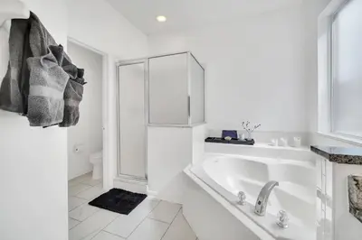 a white bathroom with a tub and a sink at Galactic 7-Bedroom Villa 3 Miles to Disney Star Wars Galaxy Edge in Kissimmee