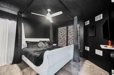 a black room with a bed with a ceiling fan at Galactic 7-Bedroom Villa 3 Miles to Disney Star Wars Galaxy Edge in Kissimmee