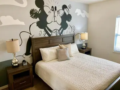 a bedroom with a bed with a disney mural on the wall at Villa Magic- Lucaya Villa Resort in Kissimmee
