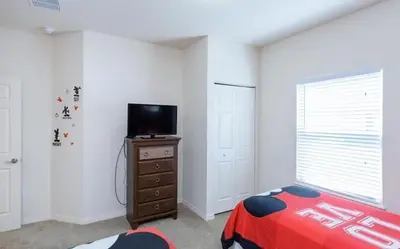 a bedroom with a bed and a television on a dresser at Villa Magic- Lucaya Villa Resort in Kissimmee
