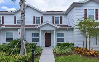 a house with a palm tree in front of it at Villa Magic- Lucaya Villa Resort in Kissimmee