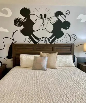 a bedroom with a bed with a disney mural on the wall at Villa Magic- Lucaya Villa Resort in Kissimmee