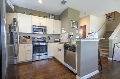 a kitchen with white cabinets and stainless steel appliances at Villa Hakuna Matata- Lucaya Village Resort in Kissimmee