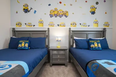 two beds in a bedroom with minions on the wall at Villa Coelho - West Lucaya Resort in Kissimmee