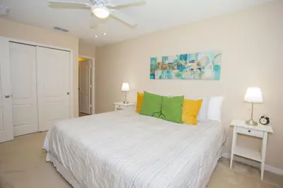 a bedroom with a white bed with a ceiling fan at Villa Compass- Compass Bay in Kissimmee