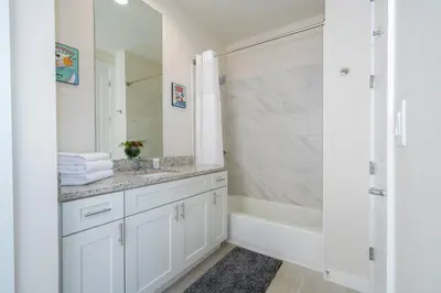 a bathroom with a sink and a tub and a mirror at Magic Villa Orlando in Orlando