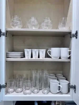 a cabinet filled with glasses and cups and plates at Magic Villa Orlando in Orlando