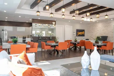 a dining room with tables and orange chairs at Magic Villa Orlando in Orlando