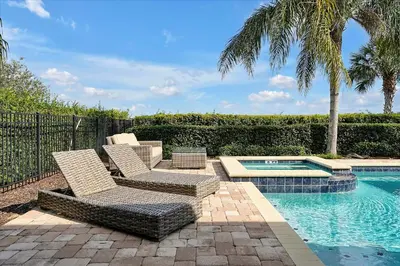 a patio with two chairs and a swimming pool at 261 LASSO DRIVE 6BED in Orlando