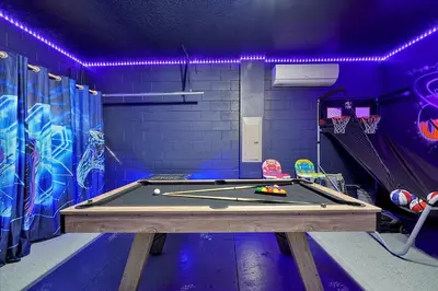 a ping pong table in a room with purple lights at 261 LASSO DRIVE 6BED in Orlando