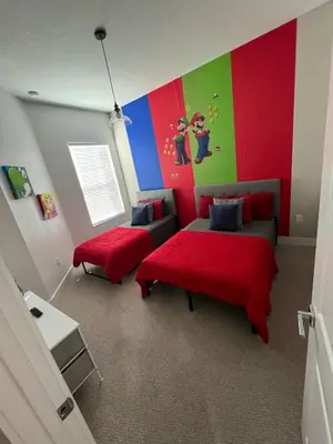a bedroom with two beds and a colorful wall at Disney here we go in Orlando