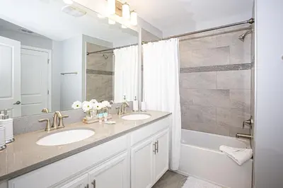 a bathroom with two sinks and a shower at Villa Ariel- Storey Lake in Kissimmee