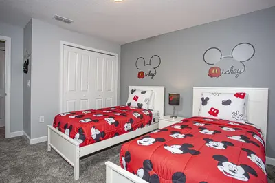 a bedroom with two beds and a red comforter with mickey ears on at Villa Ariel- Storey Lake in Kissimmee