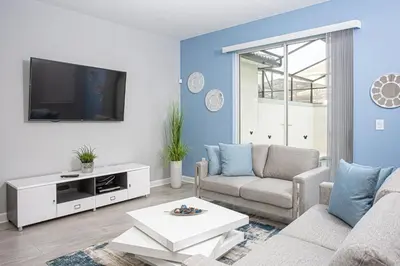 a living room with a couch and a tv at Villa Ariel- Storey Lake in Kissimmee