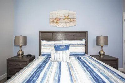 a bedroom with a bed with two night stands and two lamps at Villa Ariel- Storey Lake in Kissimmee