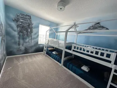a room with two bunk beds and a painting on the wall at 2476 SHANTI DRIVE 12BED in Kissimmee