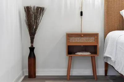 a small wooden table next to a vase with sticks at 2722 CLUB CORTILE UNIT B 3BED in Kissimmee