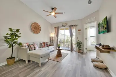 a living room with a couch and a ceiling fan at 2722 CLUB CORTILE UNIT B 3BED in Kissimmee