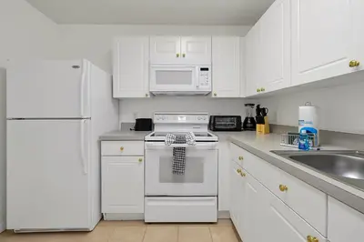 a white kitchen with white appliances and white cabinets at 2728 CLUB CORTILE CIRCLE UNIT A 3BED in Kissimmee