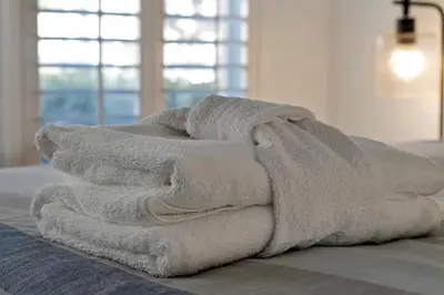 a pile of towels sitting on top of a bed at 2728 CLUB CORTILE CIRCLE UNIT A 3BED in Kissimmee