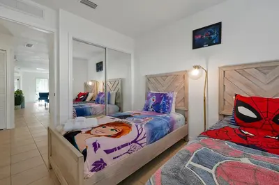 a bedroom with two beds and a mirror at 2728 CLUB CORTILE CIRCLE UNIT A 3BED in Kissimmee