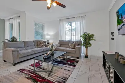 a living room with a couch and a table at Top Rated 4BR home in Kissimmee