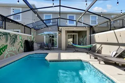 a swimming pool with a hammock and a house at Top Rated 4BR home in Kissimmee