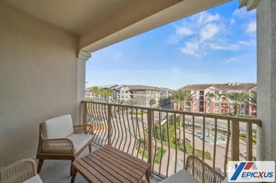 a balcony with a chair and a view of a city at The Epic Cork Vista Cay Orlando in Orlando