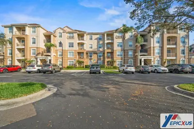 a parking lot with cars parked in front of a building at The Epic Cork Vista Cay Orlando in Orlando