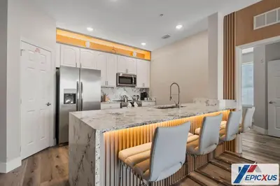 a kitchen with a large island with chairs around it at The Epic Cork Vista Cay Orlando in Orlando