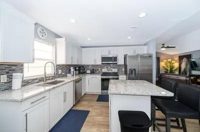 a kitchen with white cabinets and stainless steel appliances at 4820 JAMAICA LANE 4BED in Kissimmee