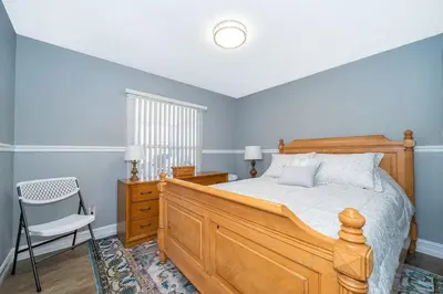 a bedroom with a wooden bed and a chair at 4820 JAMAICA LANE 4BED in Kissimmee